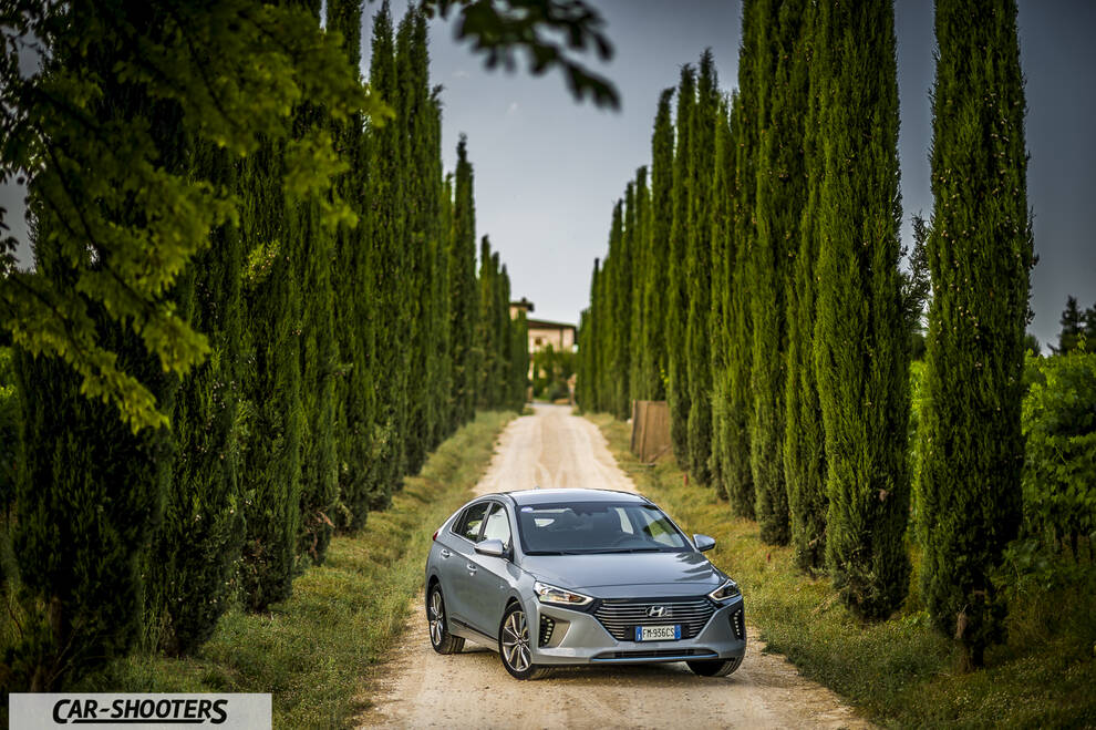 Hyundai Ioniq – front three-quarter, silver on a dirt road lined with tall trees