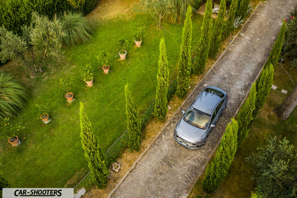 Hyundai Ioniq – front three-quarter, grey metallic on a driveway beside a grassy lawn