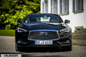 Infiniti Q60 – front three-quarter, black parked near a building
