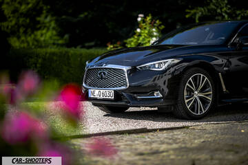 Infiniti Q60 – front three-quarter, black parked on a gravel driveway