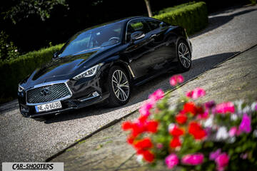 Infiniti Q60 – front three-quarter, black parked on a gravel driveway