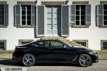 Infiniti Q60 – side profile, black in front of a building