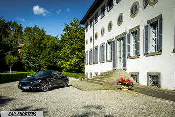 Infiniti Q60 – front three-quarter, black parked in front of a building