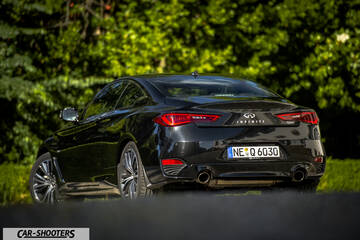 Infiniti Q60 – rear three-quarter, black against a green foliage background