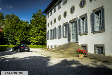 Infiniti Q60 – rear three-quarter, black parked near historic building