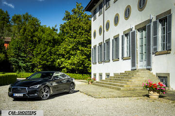 Infiniti Q60 – front three-quarter, black parked beside a large building