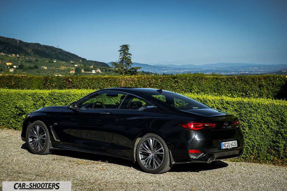 Infiniti Q60 – rear three-quarter, black against a mountain backdrop