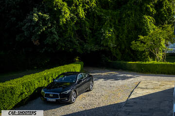 Infiniti Q60 – front three-quarter, black parked on a gravel driveway