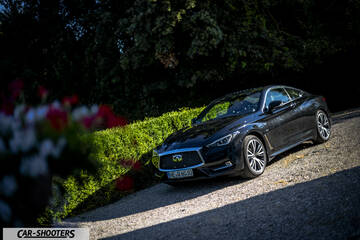 Infiniti Q60 – front three-quarter, black on a gravel driveway