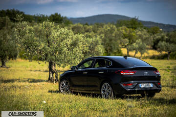 Hyundai I30 Fastback – rear three-quarter, black in a grassy field