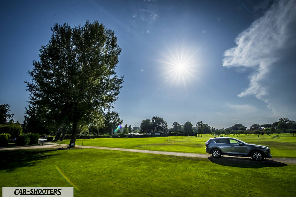 Mazda CX 5 – side profile, grey metallic on a golf course under bright sun
