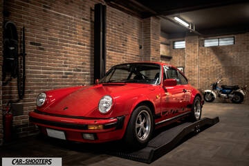 Porsche – front three-quarter, red in a brick garage