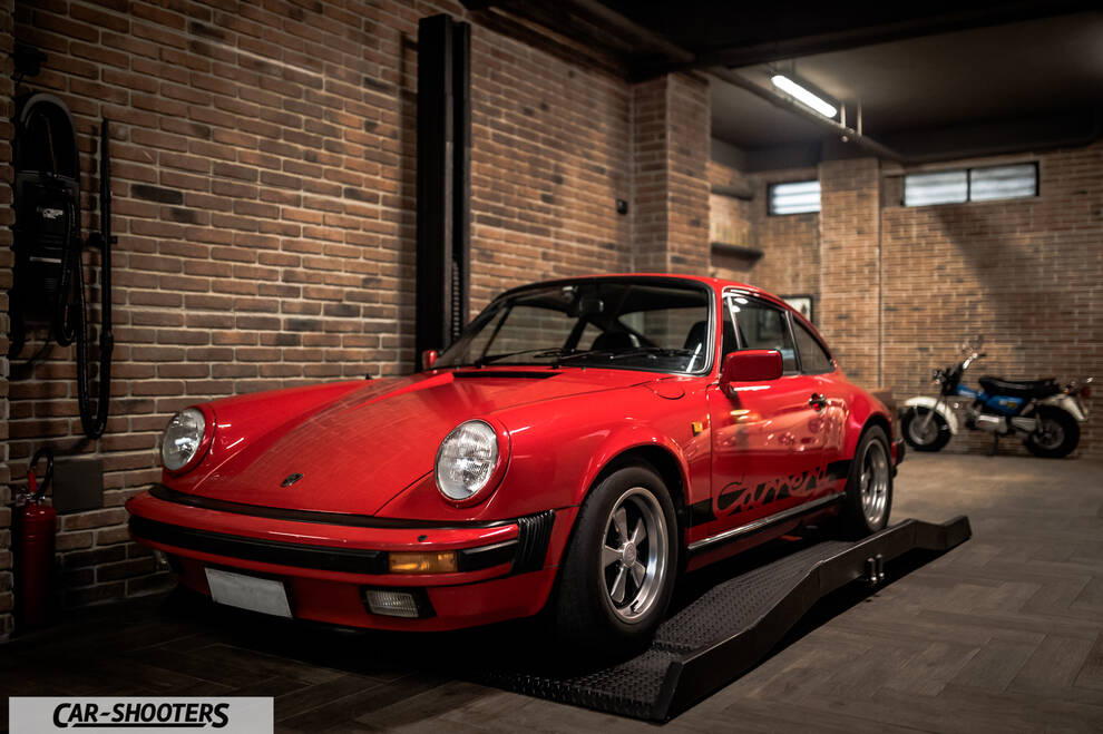 Porsche – front three-quarter, red in a brick garage