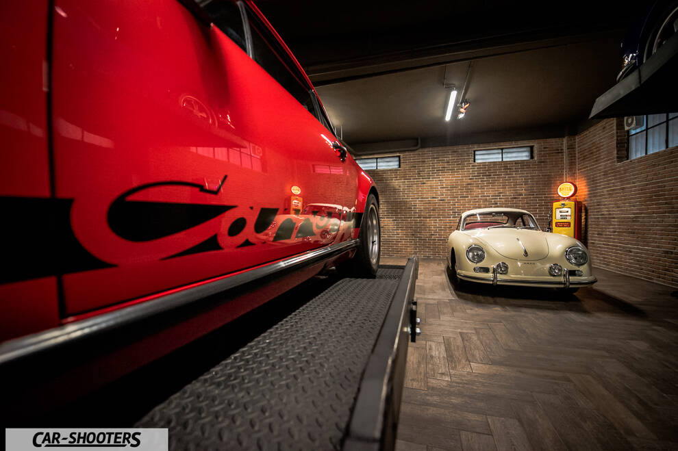 Porsche – side profile, red on a lift in a garage