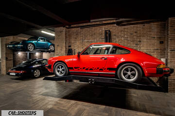 Porsche &ndash; side profile, red on a car lift in a brick garage