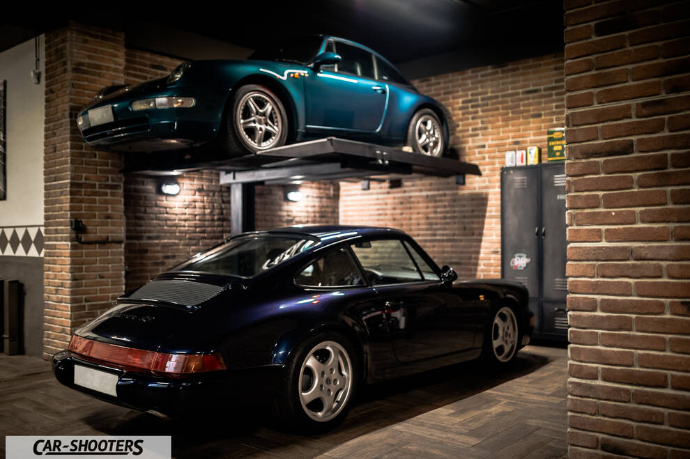 Porsche – rear three-quarter, dark blue in a brick garage with car lift