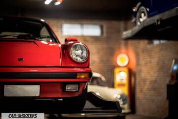 Porsche – front three-quarter, red in a garage with brick walls