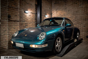 Porsche – front three-quarter, teal metallic in a brick garage
