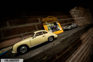 Porsche – front three-quarter, cream on a shelf against a brick wall