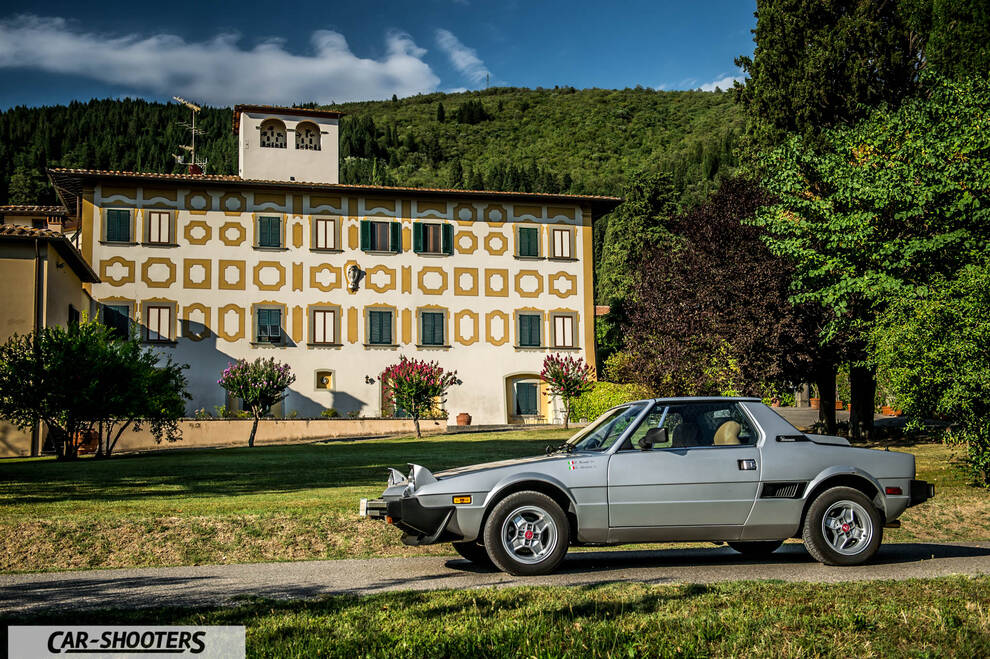Fiat X1 9 Storia – side profile, silver on a country road against a large building backdrop