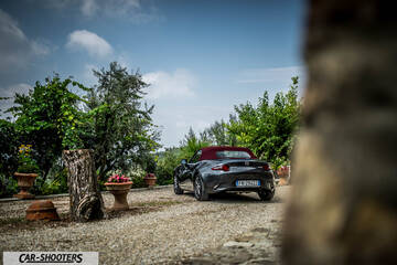 Mazda MX 5 Cherry Edition – rear three-quarter, dark grey metallic on a gravel courtyard