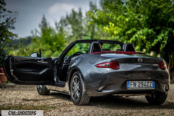 Mazda MX 5 Cherry Edition – rear three-quarter, grey metallic on a gravel road