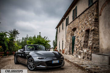Mazda MX 5 Cherry Edition – front three-quarter, grey metallic parked beside a stone building