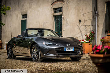 Mazda MX 5 Cherry Edition – front three-quarter, dark grey metallic on a gravel courtyard