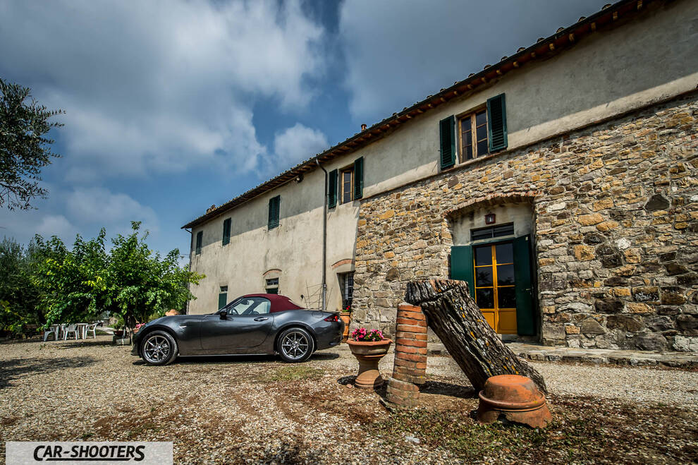 Mazda MX 5 Cherry Edition – side profile, dark grey parked beside a stone building