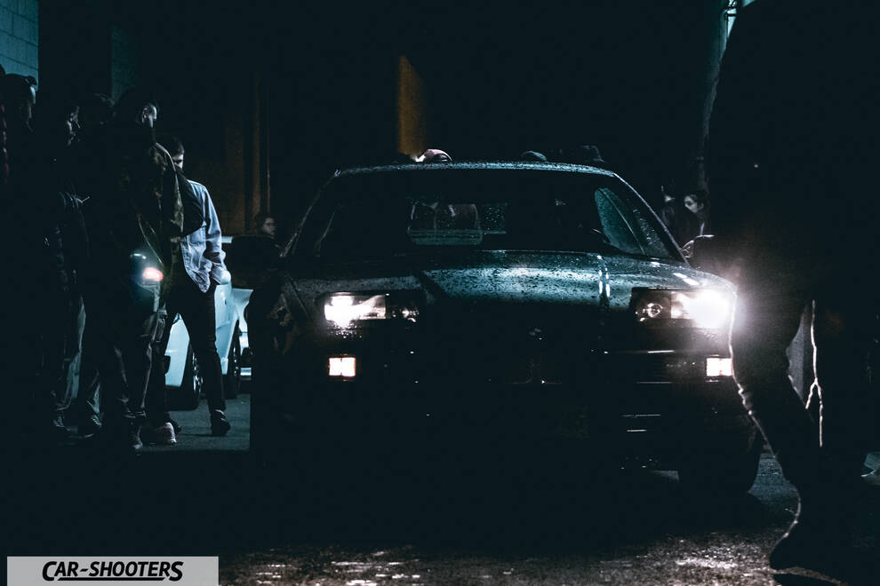 front three-quarter, black at night surrounded by people