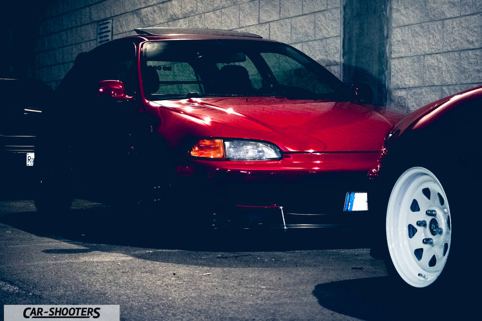 front three-quarter, red in a parking lot