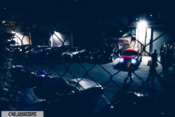 front three-quarter, red in a parking lot at night