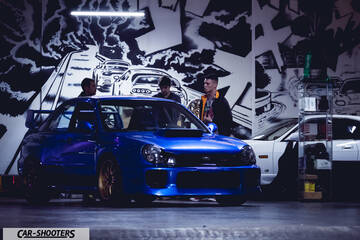 front three-quarter, blue in a garage with graffiti wall