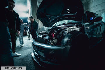 engine bay, surrounded by people indoors