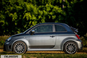 Abarth 695 Rivale – side profile, grey metallic against a leafy background