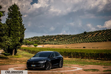 Tesla Model X – front three-quarter, black against a rural landscape backdrop
