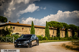Tesla Model X – front three-quarter, black against an old stone building