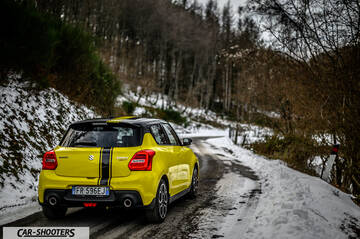 Suzuki Swift Sport – rear three-quarter, yellow on a snowy winding road