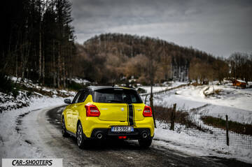 Suzuki Swift Sport – rear three-quarter, yellow against a snowy mountain backdrop