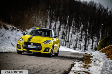 Suzuki Swift Sport – front three-quarter, yellow on a snowy winding road