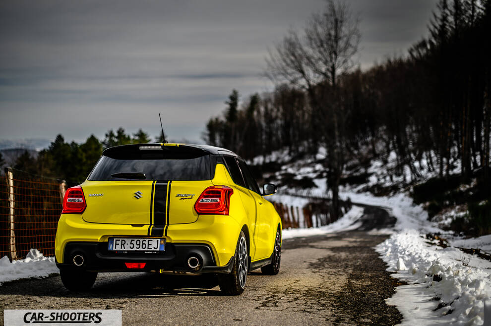 Suzuki Swift Sport – rear view, yellow on a snowy country road