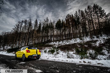 Suzuki Swift Sport – rear three-quarter, yellow against a snowy forest backdrop