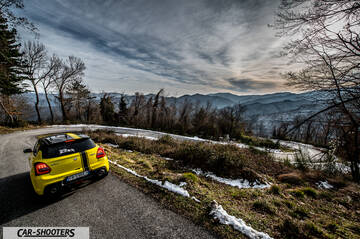 Suzuki Swift Sport – rear three-quarter, yellow on a mountain road