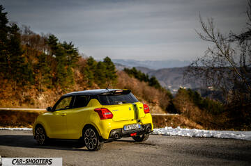 Suzuki Swift Sport – rear three-quarter, yellow on a winding mountain road