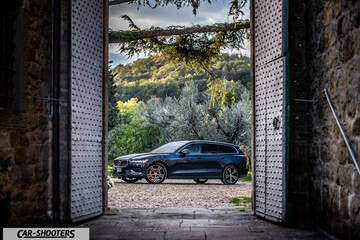 Volvo V60 – side profile, dark blue framed by stone doorway