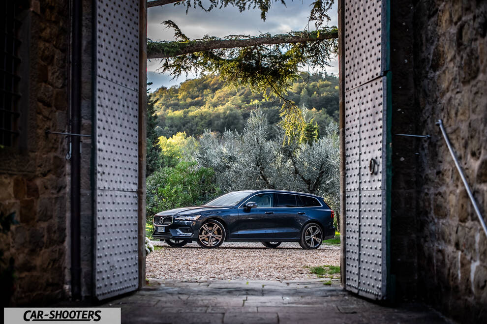 Volvo V60 – side profile, dark blue framed by stone doorway