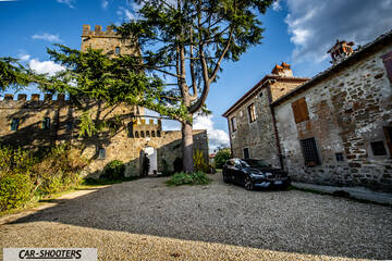 Volvo V60 – front three-quarter, black in a medieval courtyard