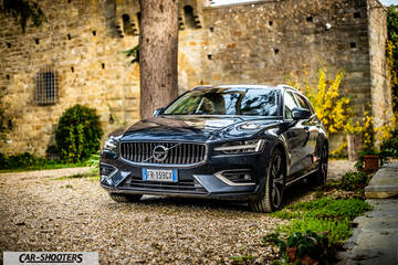 Volvo V60 – front three-quarter, dark blue parked on a gravel courtyard
