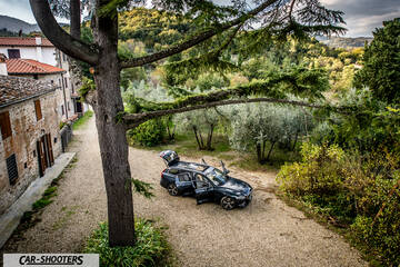 Volvo V60 – front three-quarter, dark grey on a gravel path