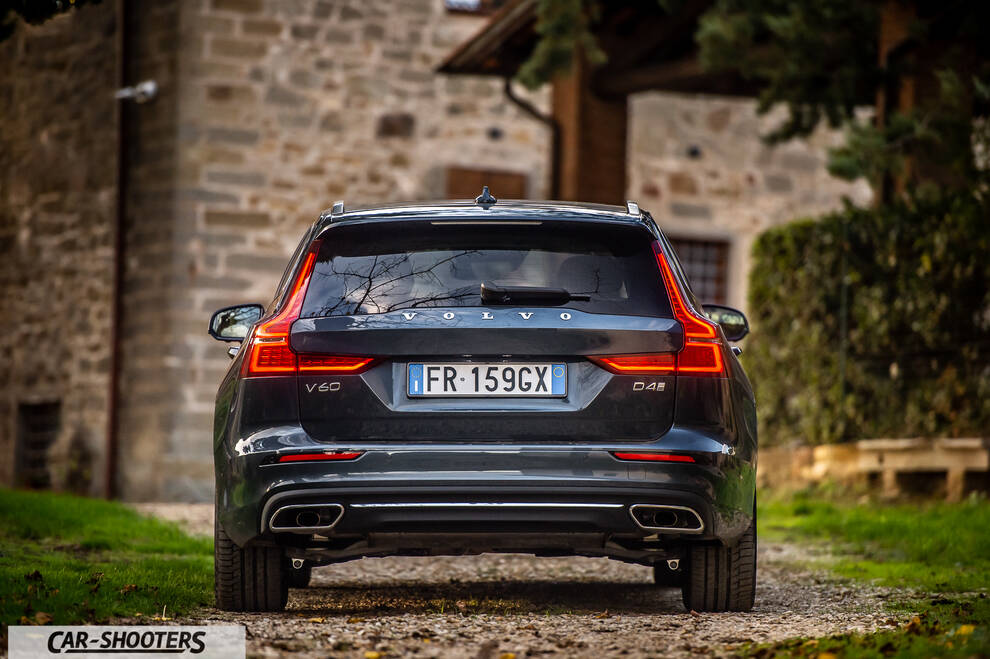 Volvo V60 – rear view, dark grey against a stone building